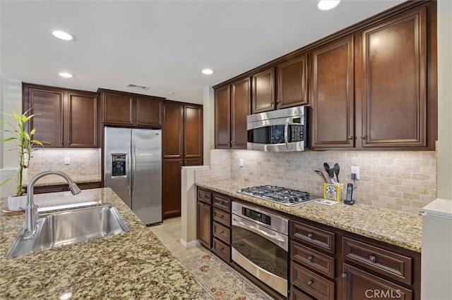 45 Brownstone Way, Aliso Viejo, CA 92656 - kitchen featuring appliances with stainless steel finishes, a sink, decorative backsplash, light stone countertops, and recessed lighting