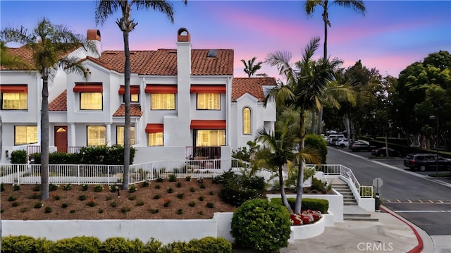 19431 Ranch Ln Unit 101, Huntington Beach, CA 92648 - view of front of property featuring stucco siding, a tile roof, and a chimney