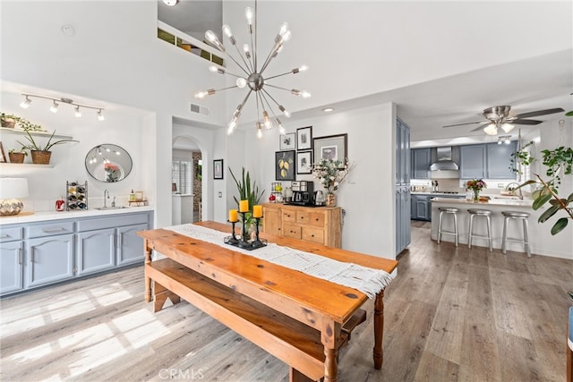 19431 Ranch Ln Unit 101, Huntington Beach, CA 92648 - dining room with arched walkways, light wood-style floors, a ceiling fan, and a chandelier