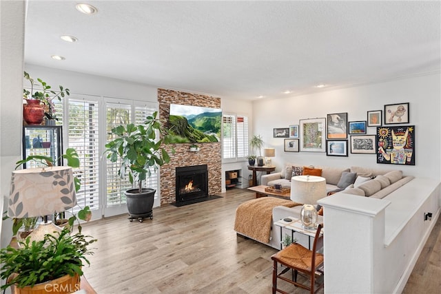 19431 Ranch Ln Unit 101, Huntington Beach, CA 92648 - living area with wood finished floors, a stone fireplace, a textured ceiling, and recessed lighting