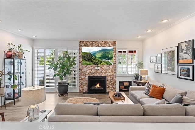 19431 Ranch Ln Unit 101, Huntington Beach, CA 92648 - living area with wood finished floors, a textured ceiling, ornamental molding, a stone fireplace, and healthy amount of natural light