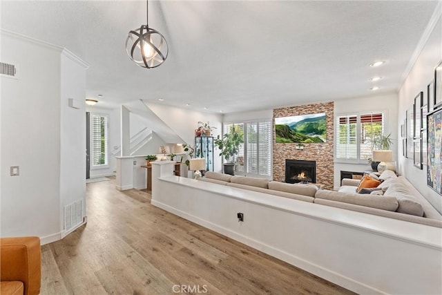 19431 Ranch Ln Unit 101, Huntington Beach, CA 92648 - living room with plenty of natural light, a fireplace, light wood-style floors, recessed lighting, and ornamental molding