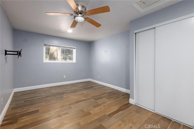 799 Fern Dr, Crestline, CA 92325 - unfurnished bedroom featuring wood-type flooring, a closet, baseboards, and a ceiling fan