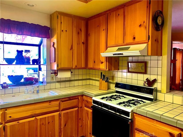 762 Esquimoux Dr, Green Valley Lake, CA 92341 - kitchen with white gas range oven, under cabinet range hood, decorative backsplash, and light countertops