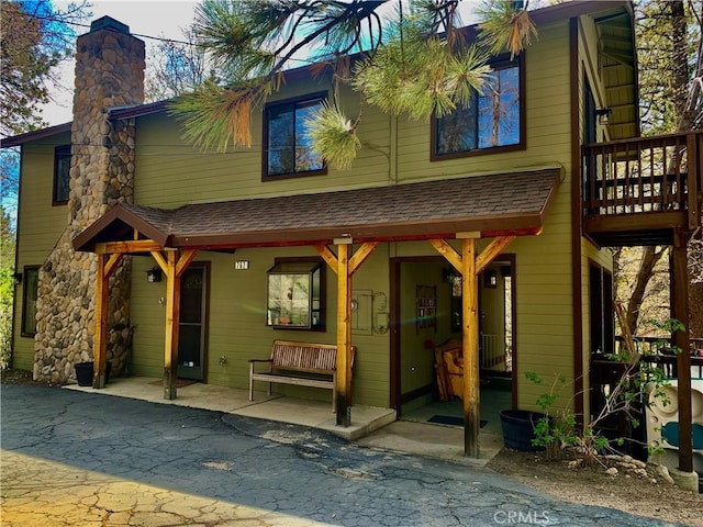 762 Esquimoux Dr, Green Valley Lake, CA 92341 - back of house featuring a chimney, a shingled roof, and a porch