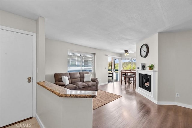 26762 Claudette St Unit 417, Canyon Country, CA 91351 - living room with wood finished floors, ceiling fan, baseboards, and a textured ceiling