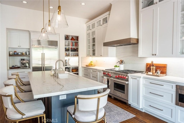 26941 Redwood Bluff Ln, Valencia, CA 91381 - kitchen featuring premium range hood, high quality appliances, a sink, white cabinetry, and dark wood-style flooring