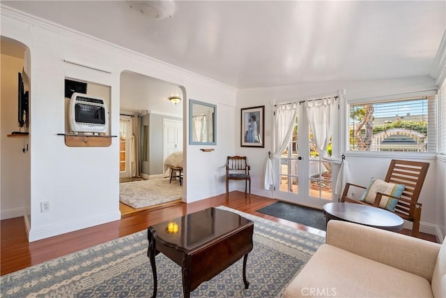 418 Tulare Ave, Morro Bay, CA 93442 - living room with wood finished floors, arched walkways, baseboards, heating unit, and ornamental molding
