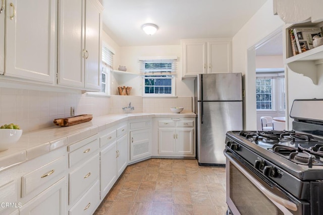 3349 Wood Ter, Los Angeles, CA 90027 - kitchen with stainless steel appliances, open shelves, tile counters, white cabinets, and a sink