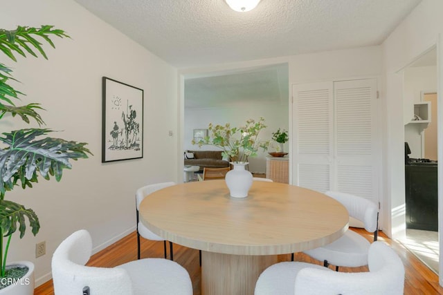 3349 Wood Ter, Los Angeles, CA 90027 - dining area featuring wood finished floors, a textured ceiling, and baseboards