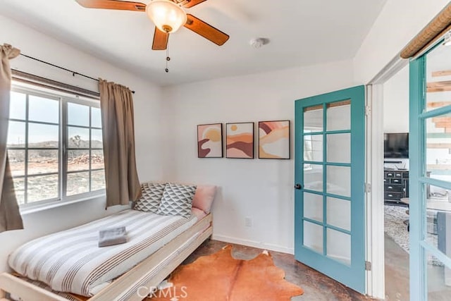 58725 Botkin Rd, Landers, CA 92285 - bedroom featuring multiple windows, baseboards, concrete flooring, and ceiling fan