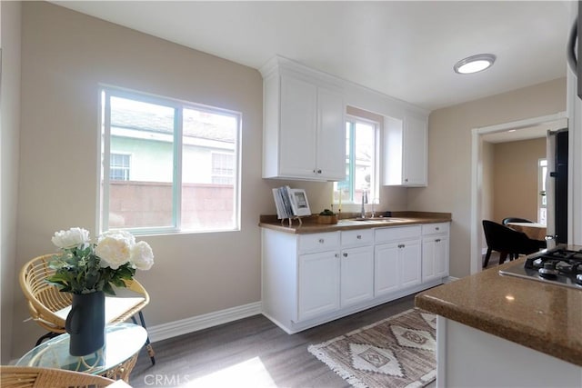 1023 W 186th St, Gardena, CA 90248 - kitchen featuring a sink, light wood-style flooring, stainless steel gas cooktop, white cabinetry, and dark countertops