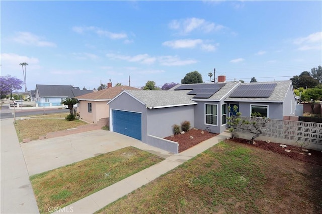1023 W 186th St, Gardena, CA 90248 - ranch-style home with roof mounted solar panels, driveway, stucco siding, an attached garage, and a shingled roof