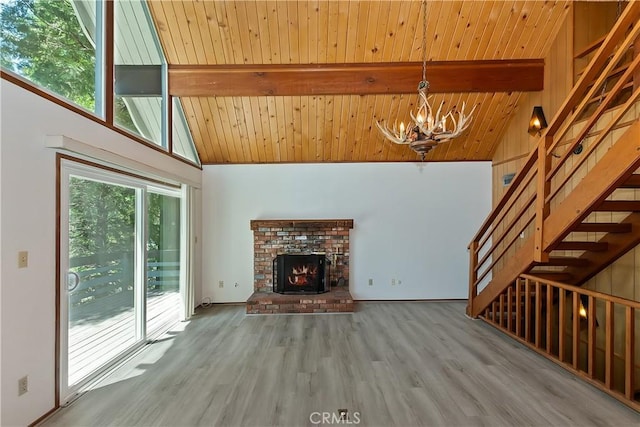 24141 Zell Ct, Crestline, CA 92325 - unfurnished living room featuring a chandelier, wood ceiling with exposed beams, high vaulted ceiling, wood finished floors, and stairway