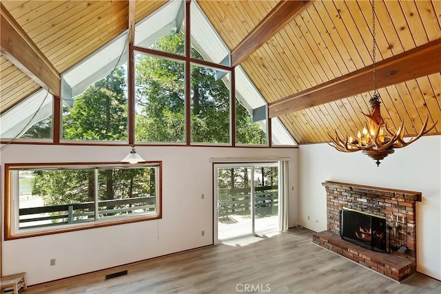 24141 Zell Ct, Crestline, CA 92325 - unfurnished living room featuring a chandelier, a brick fireplace, wood finished floors, wooden ceiling with exposed beams, and high vaulted ceiling