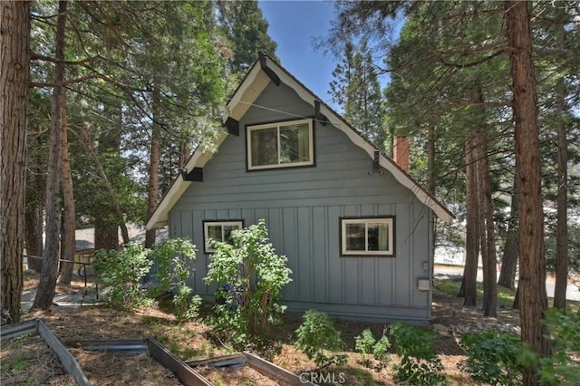 24141 Zell Ct, Crestline, CA 92325 - view of home's exterior with board and batten siding and a chimney