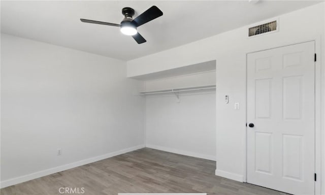 7686 Deer Trl, Yucca Valley, CA 92284 - unfurnished bedroom with wood finished floors, baseboards, a closet, and a ceiling fan