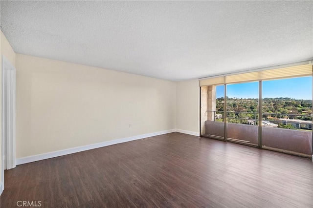 24055 Paseo Del Lago Unit 1206, Laguna Woods, CA 92637 - spare room with dark wood-style floors, baseboards, a textured ceiling, and floor to ceiling windows