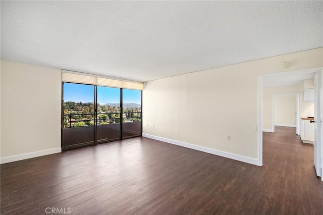 24055 Paseo Del Lago Unit 1206, Laguna Woods, CA 92637 - empty room with dark wood-type flooring, baseboards, floor to ceiling windows, and a mountain view