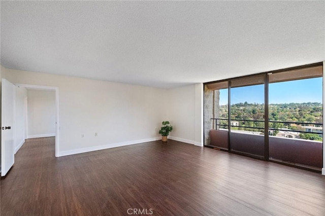 24055 Paseo Del Lago Unit 1206, Laguna Woods, CA 92637 - unfurnished room with wood finished floors, baseboards, a textured ceiling, and floor to ceiling windows
