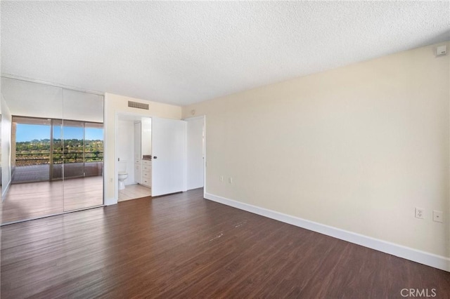 24055 Paseo Del Lago Unit 1206, Laguna Woods, CA 92637 - unfurnished room with wood finished floors, a textured ceiling, and baseboards