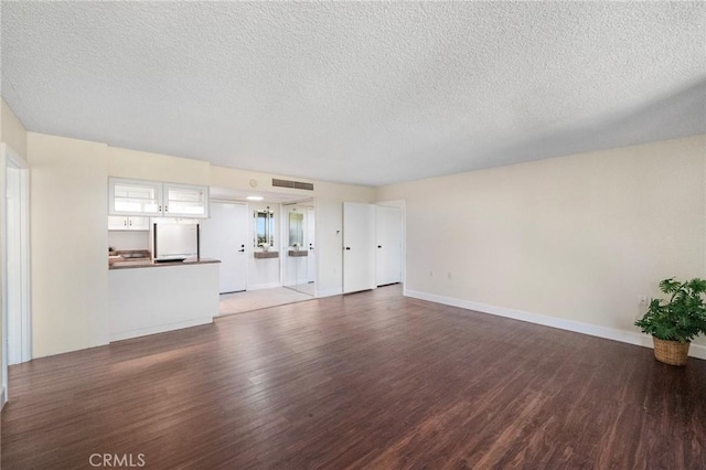24055 Paseo Del Lago Unit 1206, Laguna Woods, CA 92637 - unfurnished living room with wood finished floors, a textured ceiling, and baseboards