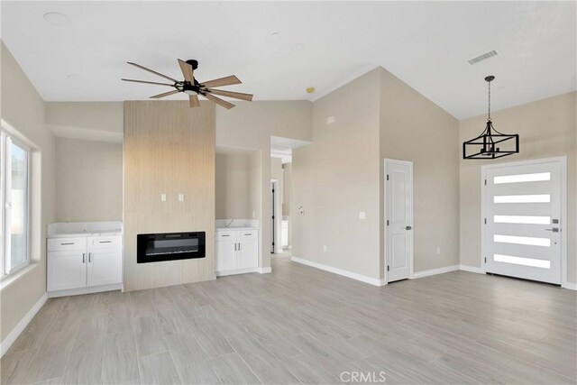 6693 Banyan Ave, Hesperia, CA 92345 - unfurnished living room featuring ceiling fan, light wood finished floors, baseboards, and high vaulted ceiling