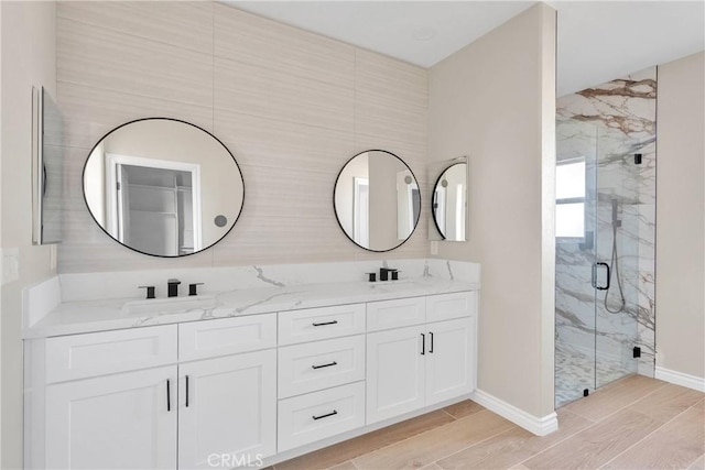 6693 Banyan Ave, Hesperia, CA 92345 - full bathroom with double vanity, a marble finish shower, wood tiled floors, and baseboards