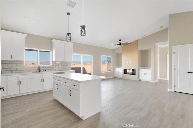 6693 Banyan Ave, Hesperia, CA 92345 - kitchen with a sink, ceiling fan, backsplash, vaulted ceiling, and light countertops
