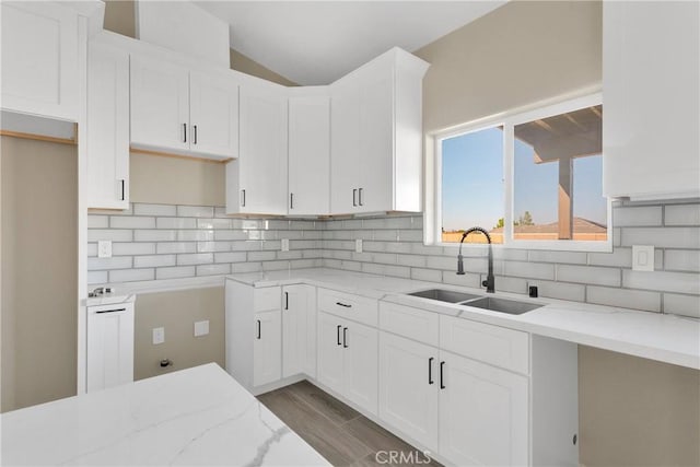 6693 Banyan Ave, Hesperia, CA 92345 - kitchen featuring a sink, light stone countertops, tasteful backsplash, lofted ceiling, and wood finished floors