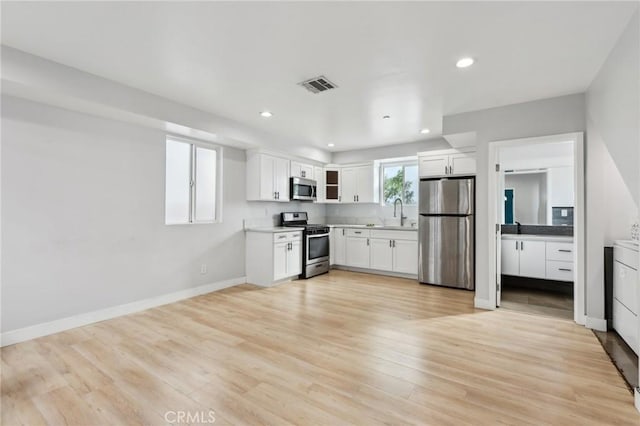 2806 Cudahy St, Huntington Park, CA 90255 - kitchen featuring appliances with stainless steel finishes, white cabinets, recessed lighting, light countertops, and light wood-style floors