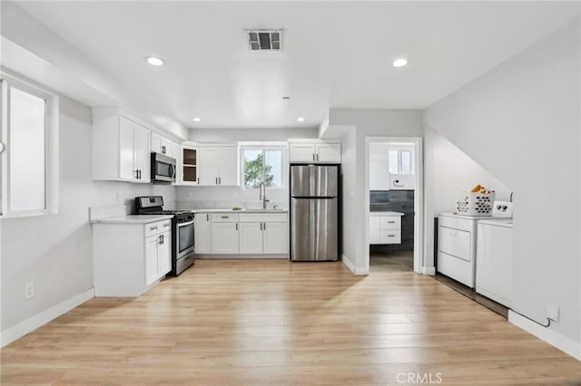 2806 Cudahy St, Huntington Park, CA 90255 - kitchen with stainless steel appliances, separate washer and dryer, white cabinetry, recessed lighting, and light countertops