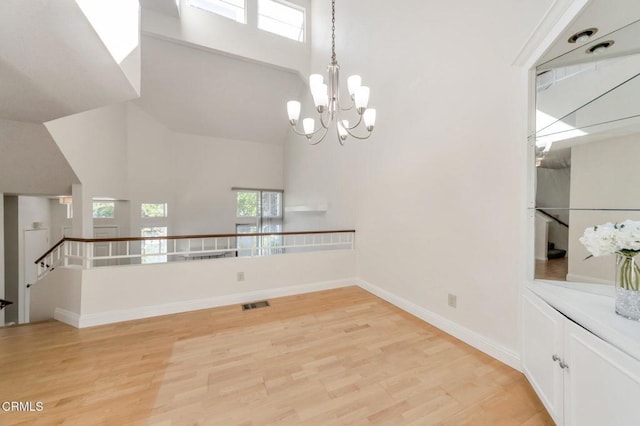1029 Gilbert Ln, Ventura, CA 93003 - unfurnished room with high vaulted ceiling, light wood-style flooring, and a chandelier