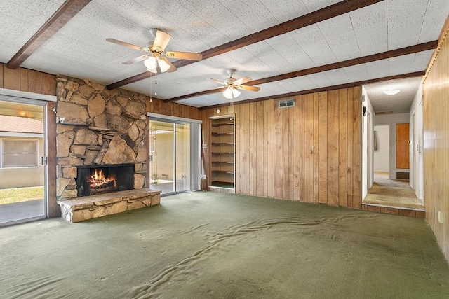 13321 Prospect Ave, North Tustin, CA 92705 - unfurnished living room featuring beamed ceiling, wooden walls, a stone fireplace, carpet flooring, and ceiling fan