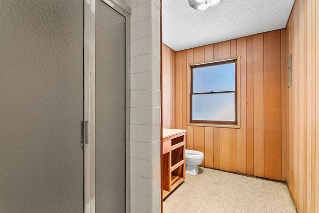 13321 Prospect Ave, North Tustin, CA 92705 - bathroom with tile patterned floors, toilet, a stall shower, and wooden walls