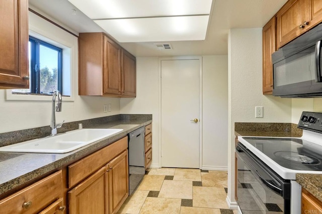 2564 Navarra Dr Unit 115, Carlsbad, CA 92009 - kitchen with black appliances, a sink, dark countertops, and brown cabinetry