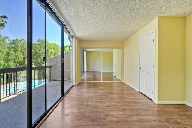 2564 Navarra Dr Unit 115, Carlsbad, CA 92009 - corridor with wood finished floors, a textured ceiling, and baseboards