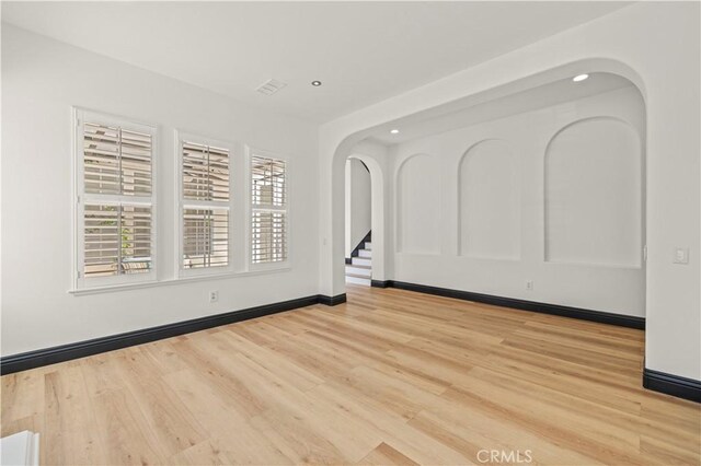 26556 Beecher Ln, Stevenson Ranch, CA 91381 - spare room with arched walkways, recessed lighting, light wood finished floors, and baseboards