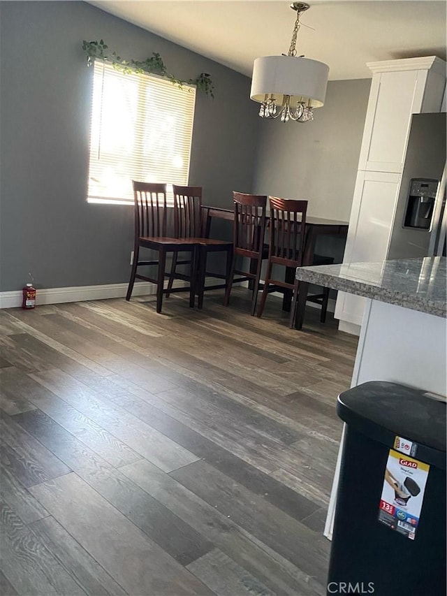 5429 Encelia Dr Unit 29, Palms, CA 92277 - dining area featuring a chandelier, dark wood finished floors, and baseboards