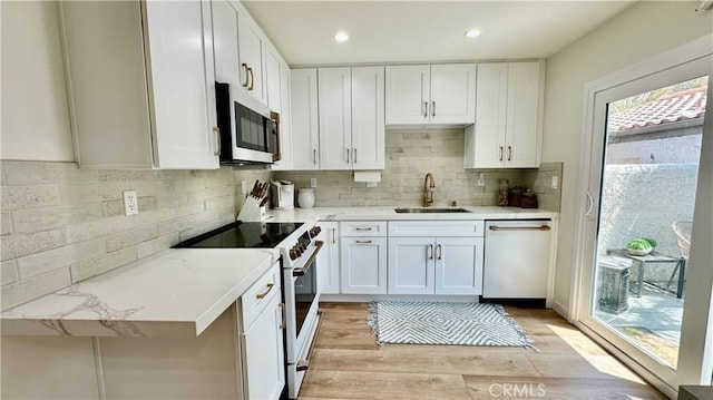 11467 Tampa Ave Unit 154, Porter Ranch, CA 91326 - kitchen with stainless steel microwave, dishwasher, white electric stove, a sink, and white cabinetry