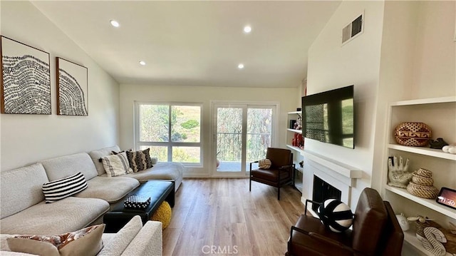 11467 Tampa Ave Unit 154, Porter Ranch, CA 91326 - living room featuring vaulted ceiling, light wood-style flooring, recessed lighting, a fireplace, and built in features