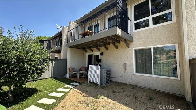 11467 Tampa Ave Unit 154, Porter Ranch, CA 91326 - rear view of house with a balcony, stucco siding, and central air condition unit