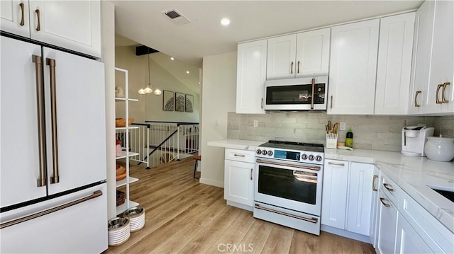 11467 Tampa Ave Unit 154, Porter Ranch, CA 91326 - kitchen featuring high end white refrigerator, gas range oven, white cabinetry, tasteful backsplash, and recessed lighting