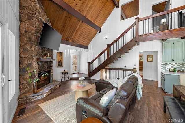 635 Grass Valley Rd, Lake Arrowhead, CA 92352 - living area featuring high vaulted ceiling, wood finished floors, wood ceiling with exposed beams, stairs, and a stone fireplace