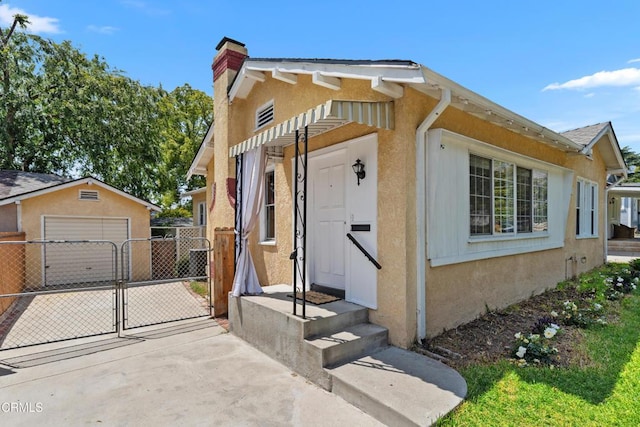 1675 N El Molino Ave, Pasadena, CA 91104 - view of front of house featuring a gate, stucco siding, an outbuilding, and a chimney
