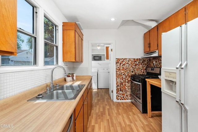 1675 N El Molino Ave, Pasadena, CA 91104 - kitchen with appliances with stainless steel finishes, under cabinet range hood, a sink, washer and dryer, and light wood finished floors
