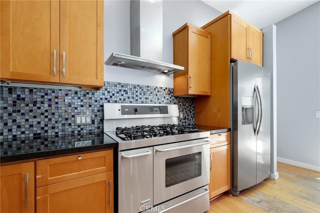 33292 Bremerton St, Dana Point, CA 92629 - kitchen with appliances with stainless steel finishes, wall chimney exhaust hood, dark countertops, light wood-style flooring, and decorative backsplash