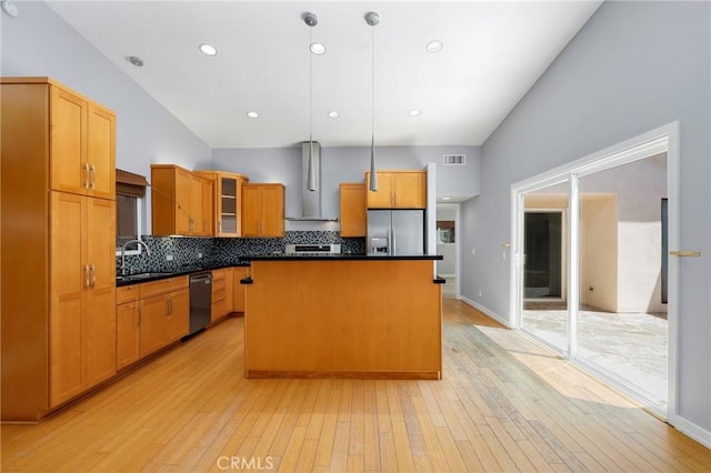 33292 Bremerton St, Dana Point, CA 92629 - kitchen with wall chimney exhaust hood, stainless steel appliances, lofted ceiling, a kitchen island, and tasteful backsplash