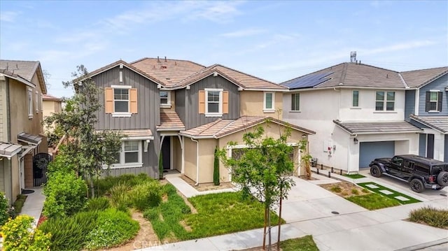 4852 S Jordan Ave, Ontario, CA 91762 - view of front of property with an attached garage, board and batten siding, driveway, stucco siding, and a tiled roof