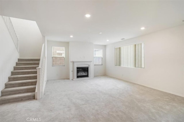 4852 S Jordan Ave, Ontario, CA 91762 - unfurnished living room with recessed lighting, carpet, stairs, and a glass covered fireplace